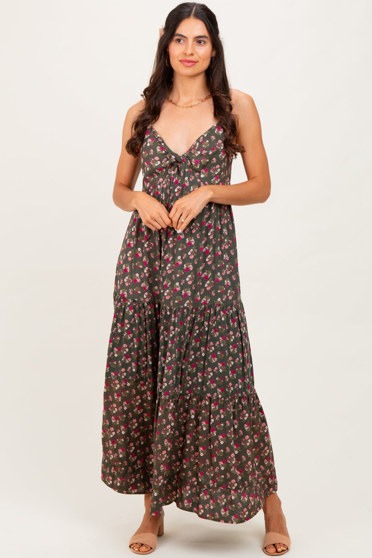 woman wearing a dark floral maxi dress with a v-neckline and tiered hem