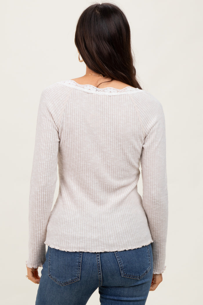 woman wearing a light gray ribbed long sleeve top with lace detailing at the neckline, seen from the back
