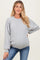woman wearing a gray maternity sweatshirt with balloon sleeves and a visible baby bump paired with blue jeans