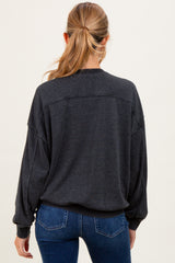 woman wearing a dark gray maternity sweatshirt with oversized fit and long sleeves, viewed from the back