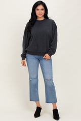 woman wearing a dark gray oversized sweatshirt with balloon sleeves and blue distressed cropped jeans