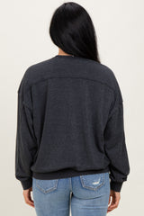 woman wearing a dark grey oversized sweatshirt with dropped shoulders and a relaxed fit paired with light blue jeans