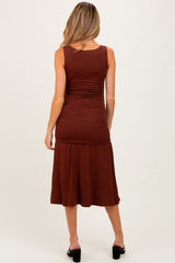 woman wearing a brown maternity dress with a fitted top and flared skirt, showing the back view