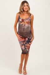 woman wearing a leopard print maternity dress with floral accents and a ruching detail, showcasing her baby bump