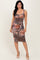 woman wearing a form-fitting floral print midi dress with a ruched front and spaghetti straps