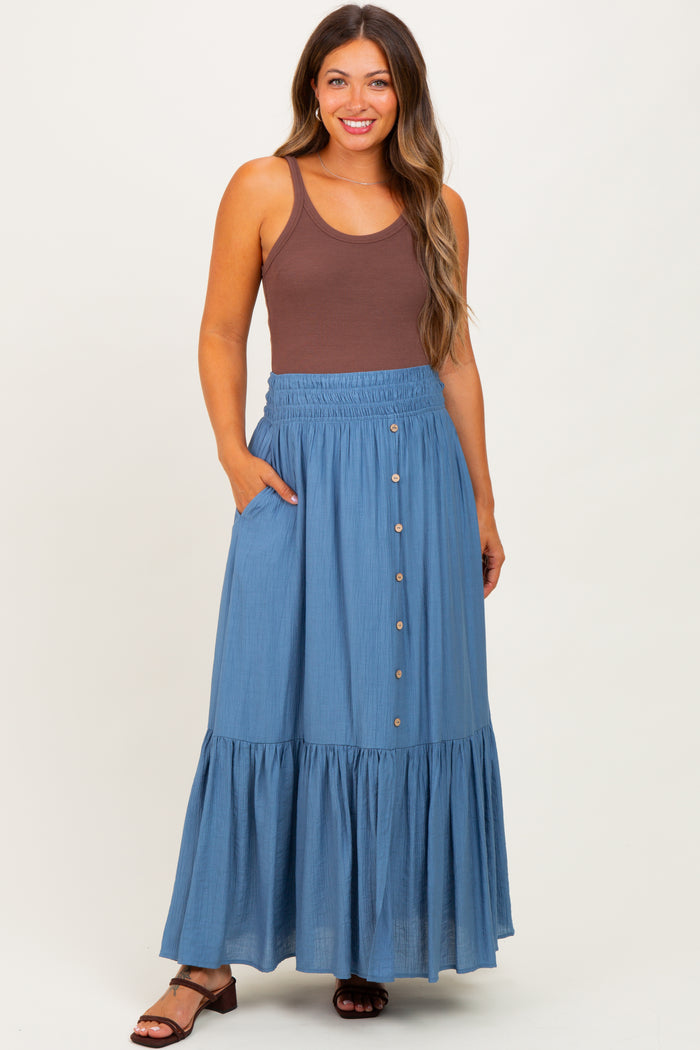 woman wearing a brown tank top and a blue maternity maxi skirt with buttons and pockets