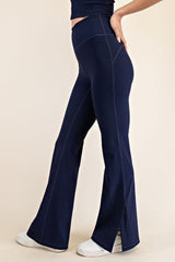 woman wearing navy blue flared yoga pants with side slits and a high waistband