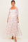 woman wearing a white floral maternity maxi dress with bell sleeves and a square neckline, showcasing her baby bump
