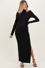 woman wearing a black long sleeve maternity maxi dress with a side slit and a baby bump visible