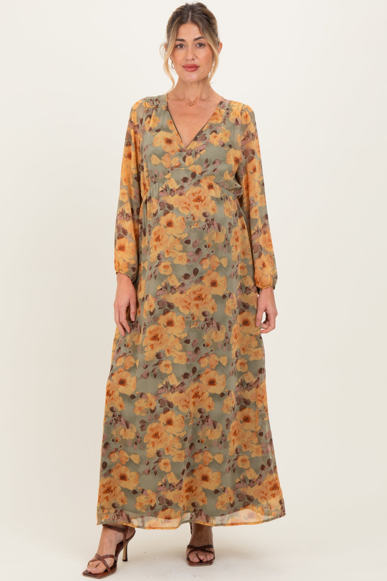woman wearing a floral long sleeve maternity maxi dress with a v-neck and a baby bump visible