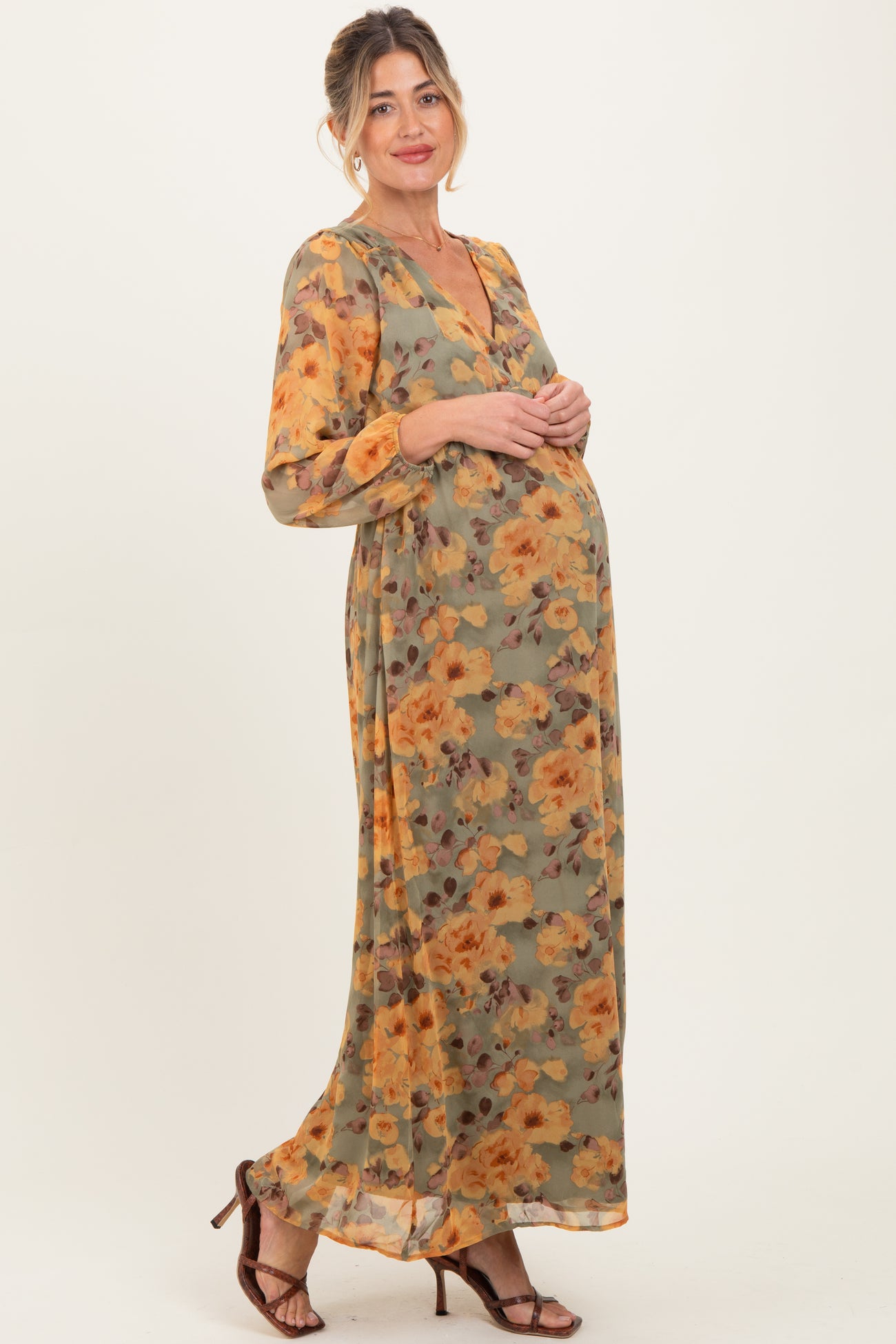 woman wearing a floral long sleeve maternity dress with a deep v-neck and a visible baby bump