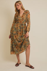 woman wearing a long sleeve olive green floral midi dress with a v-neckline and a high-low hem