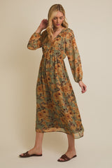 woman wearing a long-sleeve green floral maxi dress with a deep v-neck and cinched waist