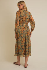 woman wearing a floral patterned long sleeve maxi dress in olive green and mustard yellow, showing the back view