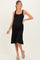 woman wearing a black maternity dress with a fitted bodice and flared skirt, showcasing her baby bump