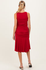 woman wearing a red sleeveless maternity dress with gathered detailing and a flared skirt, showing a baby bump from the back