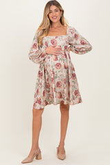 woman wearing a floral print maternity dress with long puff sleeves and a square neckline, highlighting her baby bump