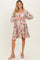 woman wearing a floral print maternity dress with long puff sleeves and a square neckline, highlighting her baby bump