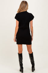 woman wearing a black ribbed maternity dress with short sleeves, showing a fitted silhouette from the back