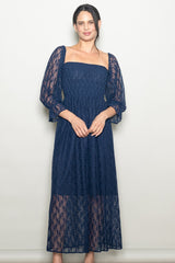 woman wearing a navy lace maxi dress with puff sleeves and a fitted bodice