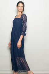 woman wearing a navy blue lace maxi dress with puff sleeves and a square neckline