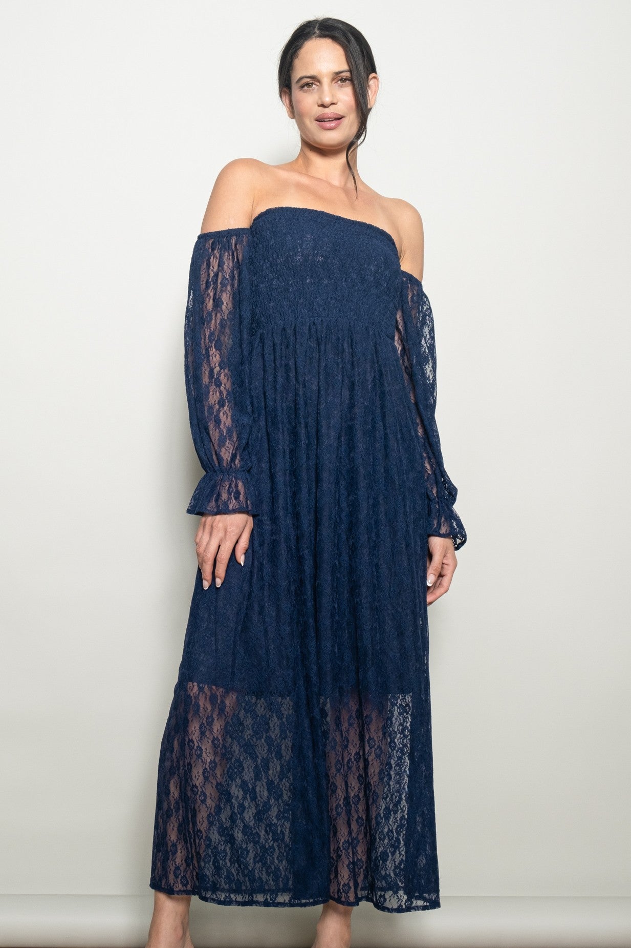 woman wearing a navy blue off-the-shoulder lace maxi dress with long sheer sleeves and a flowy silhouette