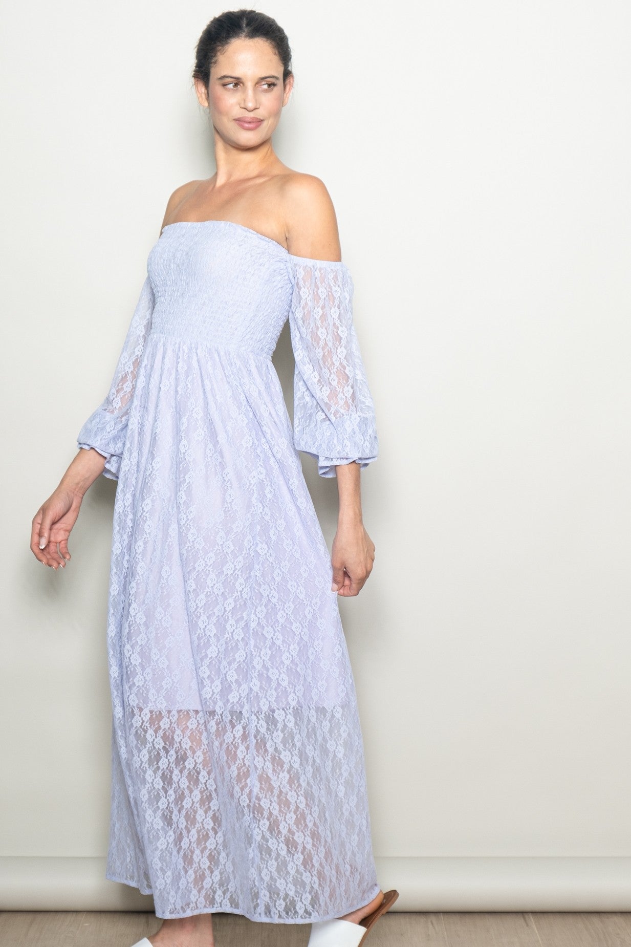 woman wearing a light purple off-the-shoulder maxi dress with lace detailing and bell sleeves