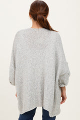 woman wearing a loose-fitting gray oversized sweater with three-quarter sleeves and a relaxed fit
