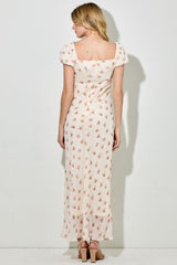 woman wearing a cream floral maxi dress with puff sleeves and a square neckline, view from the back