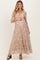 woman wearing a flowy beige floral maternity maxi dress with three-quarter sleeves and a visible baby bump