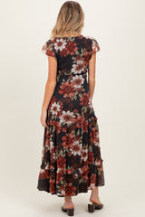 woman wearing a black floral maternity maxi dress with cap sleeves and a tiered skirt