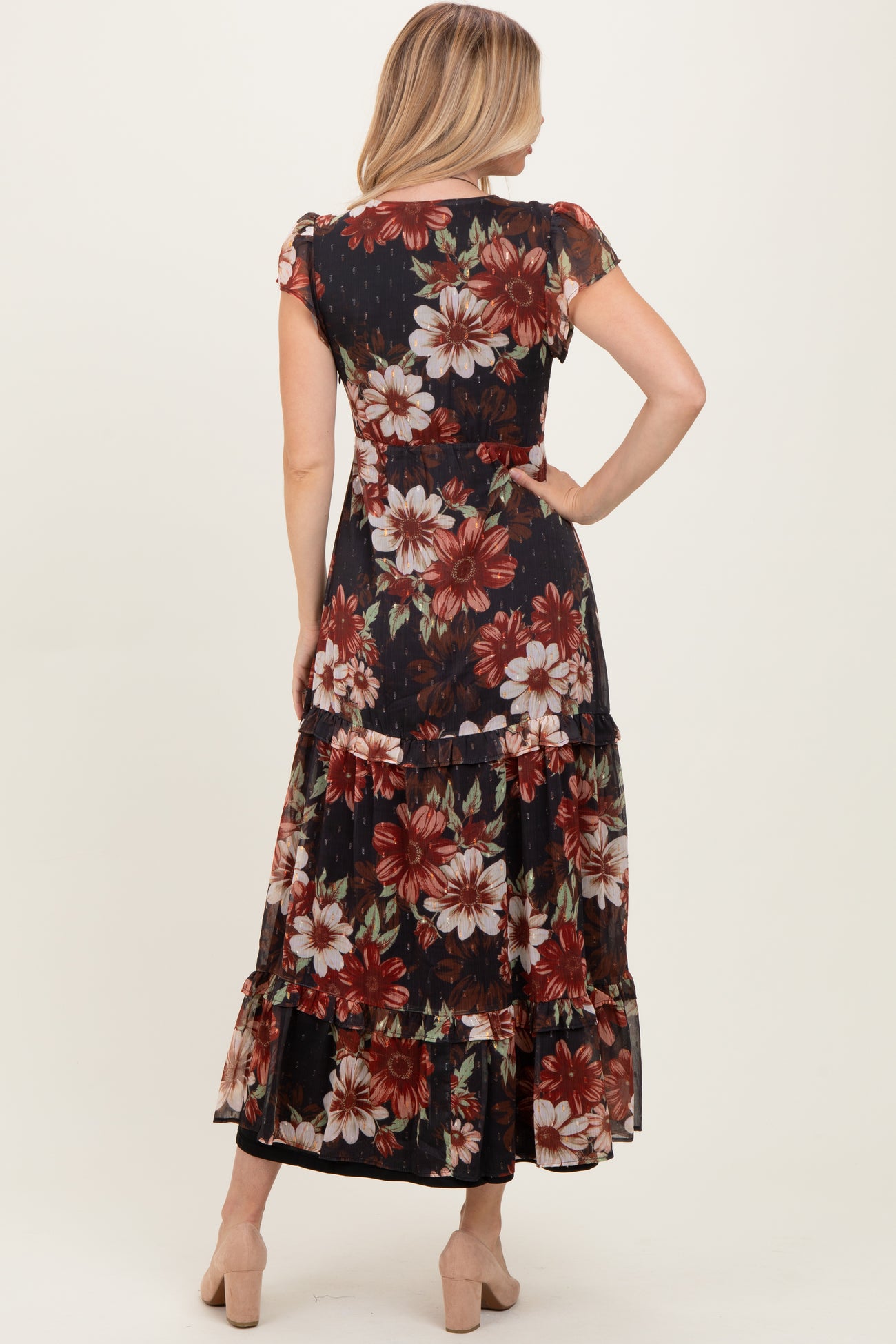 woman wearing a floral print maxi dress with short sleeves and tiered ruffles, shown from the back