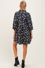 woman wearing a black floral maternity dress with three-quarter sleeves and a flowy silhouette, showing a baby bump