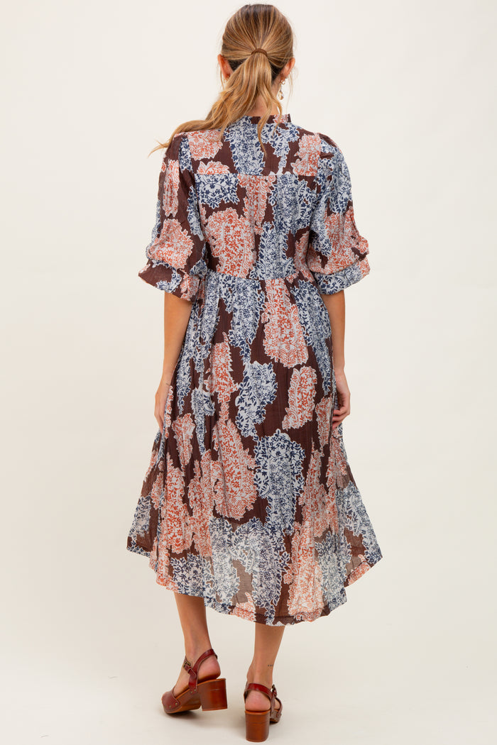 woman wearing a floral maternity wrap dress with short sleeves and a flowing midi length, showing the back view