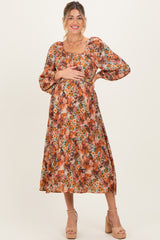 woman wearing a floral print maternity dress with puff sleeves and holding her baby bump