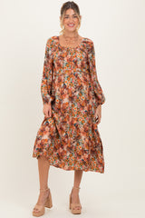 woman wearing a floral print maternity dress with long sleeves and a flowing skirt, showcasing a baby bump