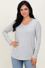 woman wearing a light gray long sleeve top with a scoop neckline and relaxed fit
