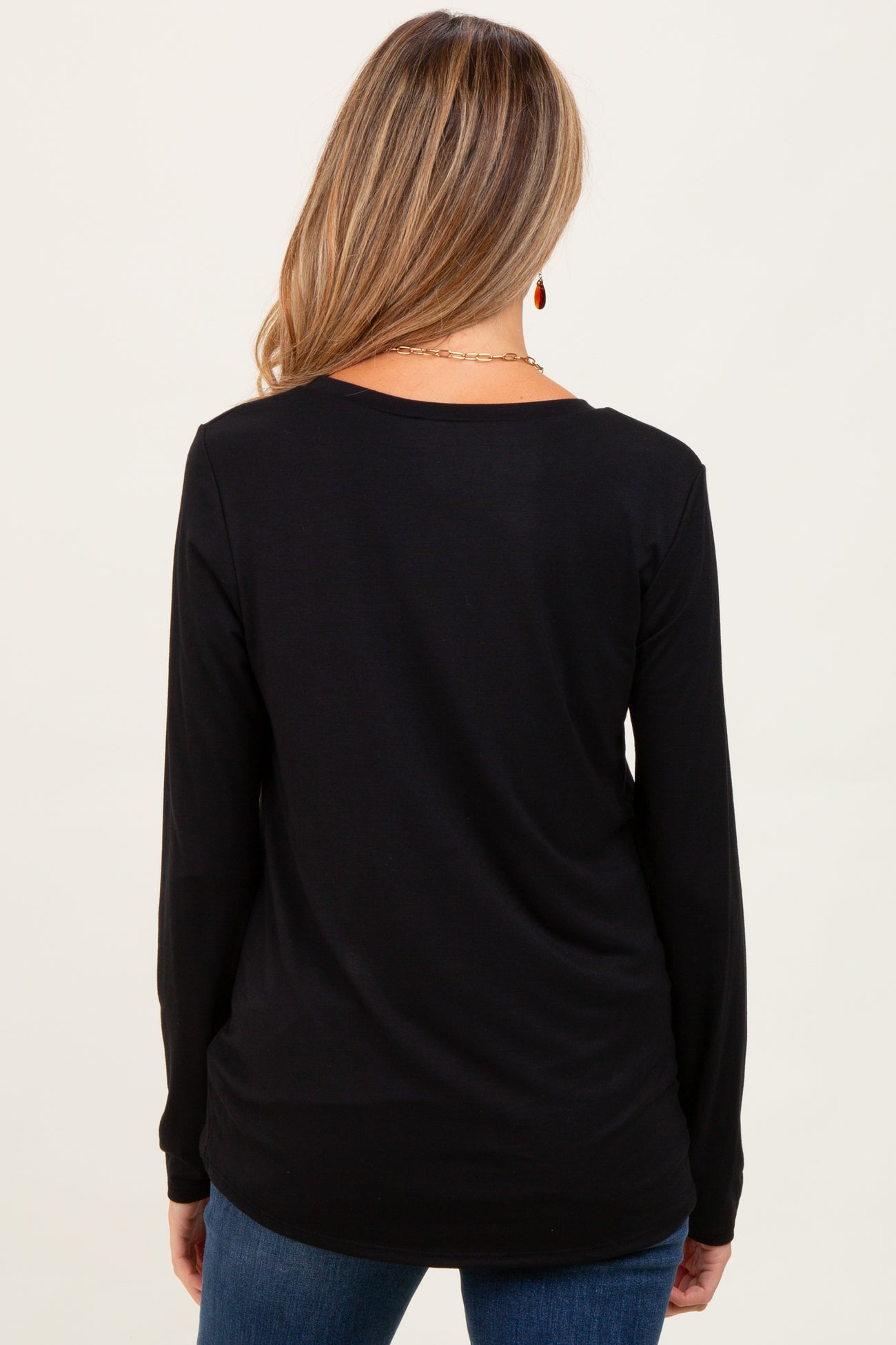 woman wearing a black long sleeve maternity top, showing the back view with a relaxed fit