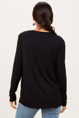 woman wearing a black long sleeve top, viewed from the back, paired with light blue jeans