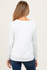 woman wearing a white long sleeve maternity top from the back with a relaxed fit and rounded neckline
