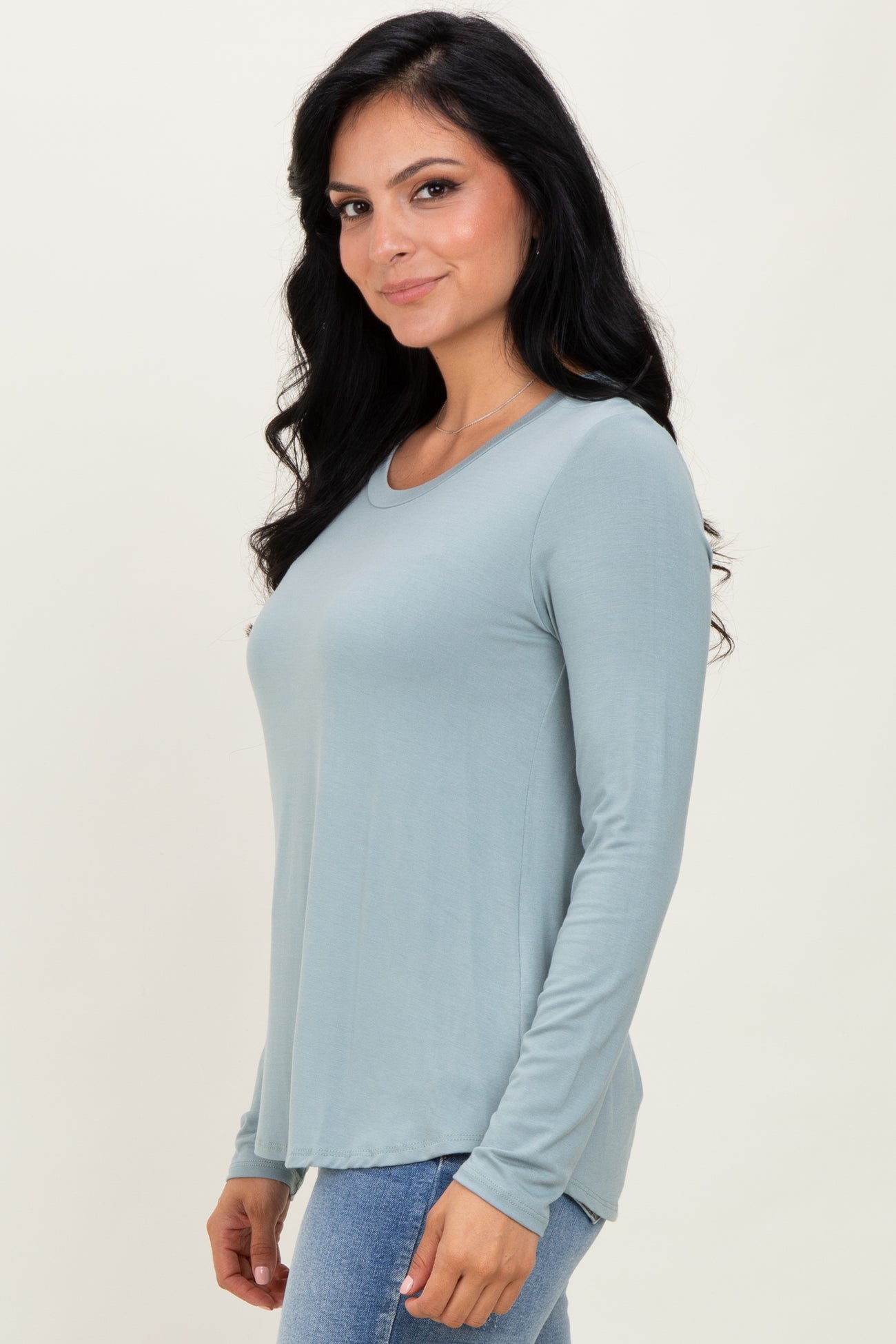 woman wearing a soft blue long sleeve top with a rounded neckline and a relaxed fit