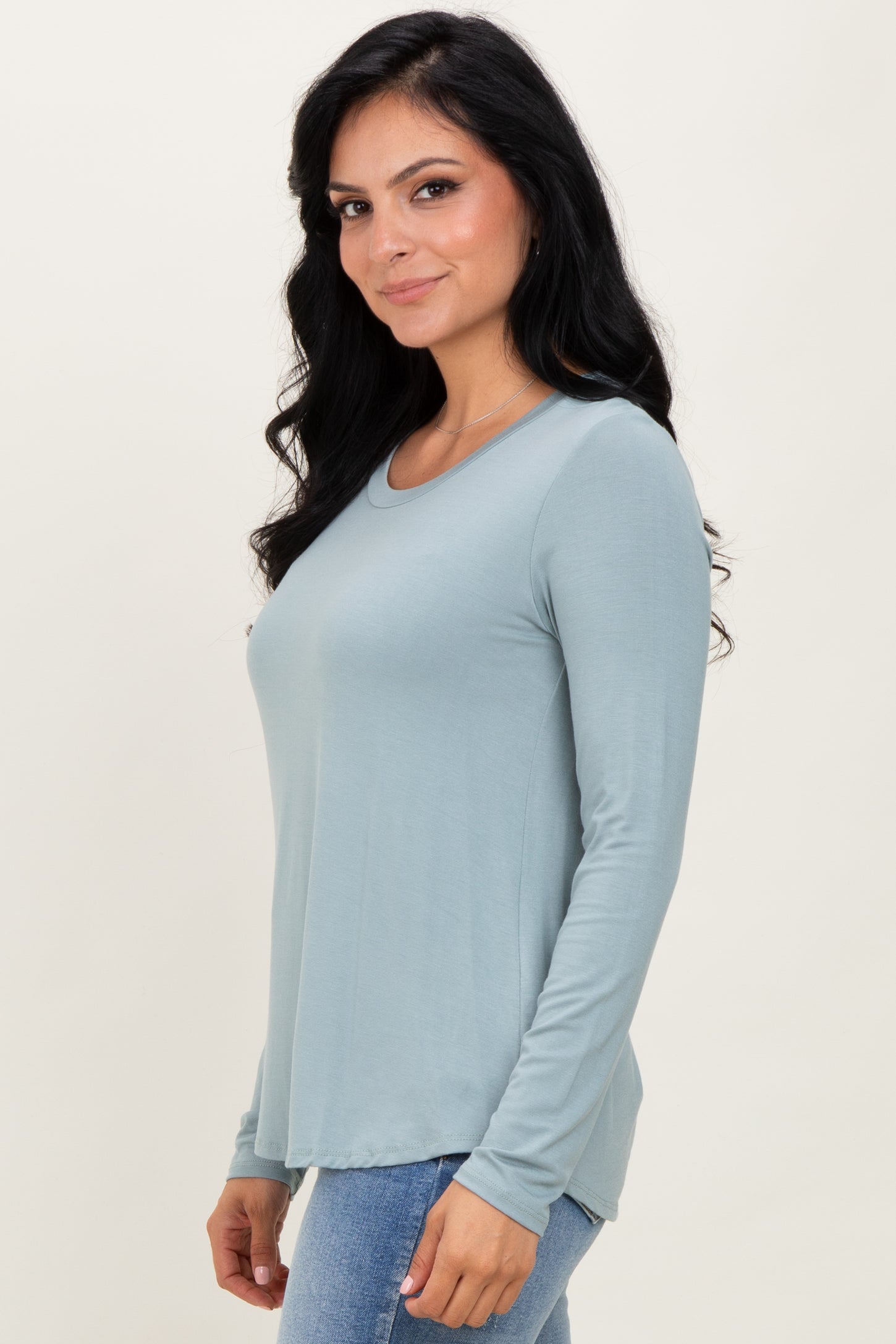 woman wearing a soft blue long sleeve top with a rounded neckline and a relaxed fit