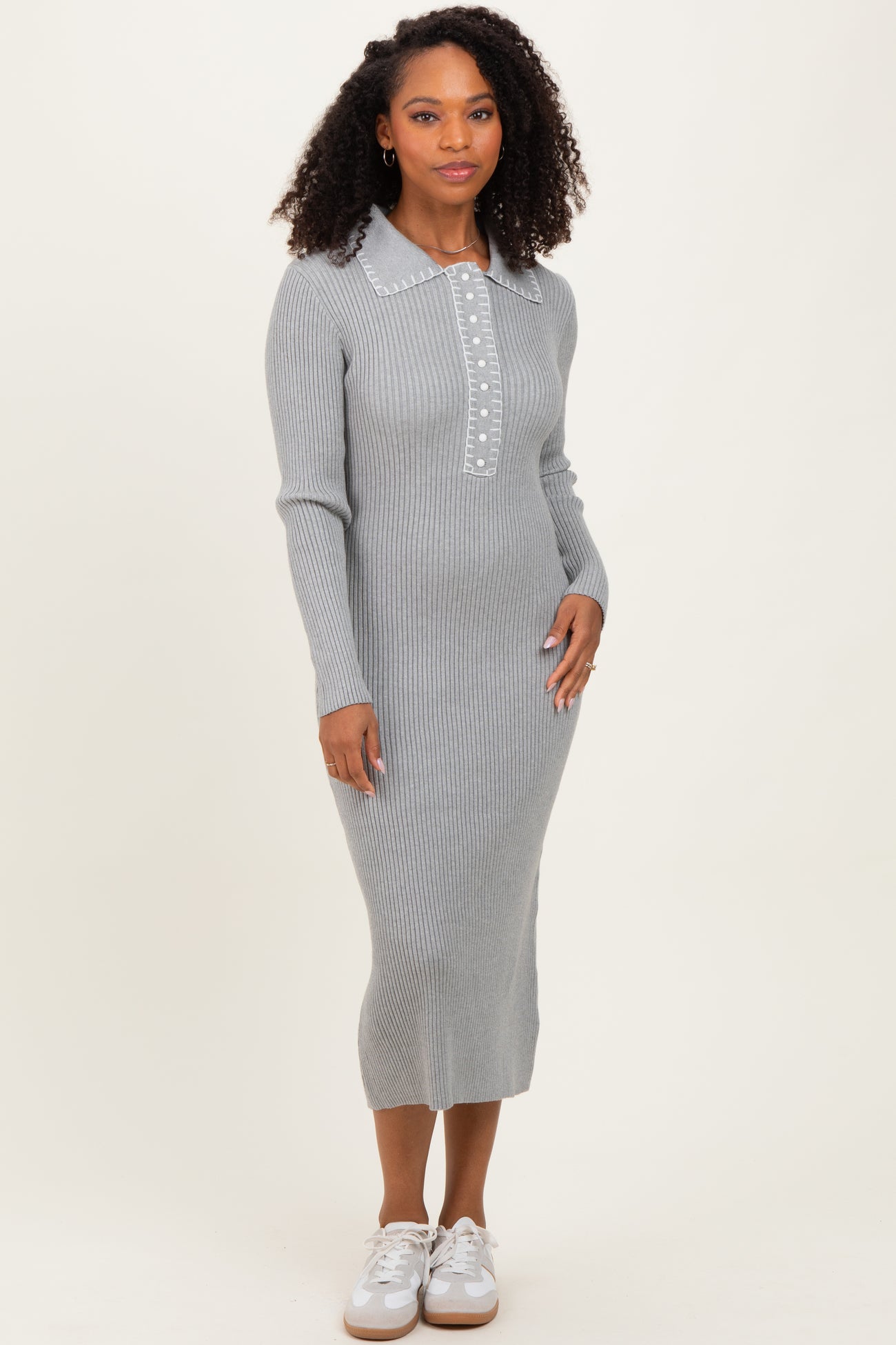 woman wearing a gray ribbed long sleeve midi dress with a collared neckline and button details
