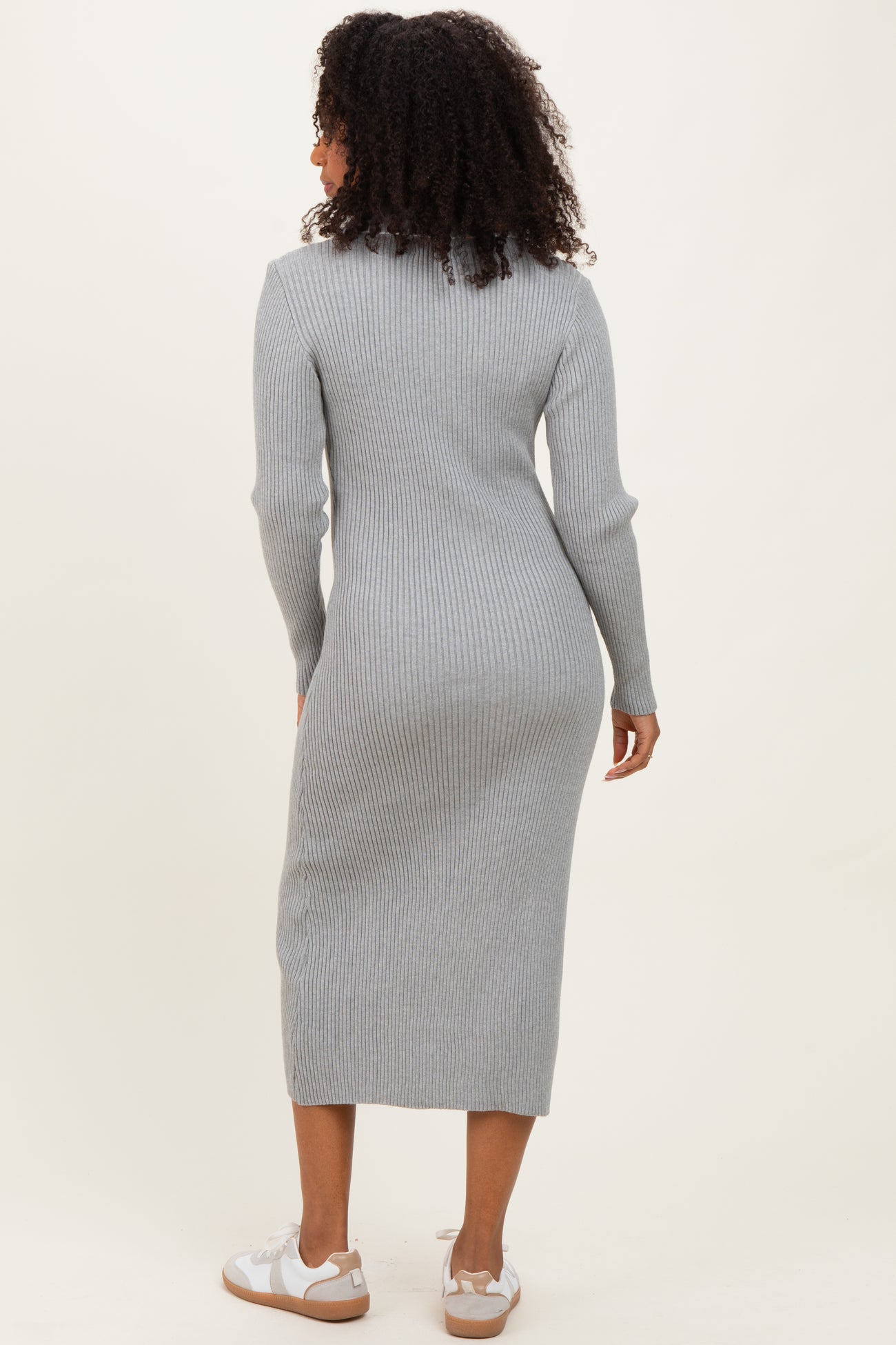 woman wearing a fitted gray ribbed midi dress and white sneakers, viewed from the back