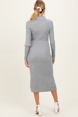 woman wearing a light grey ribbed maternity dress, view from the back, with a fitted silhouette and mid-calf length