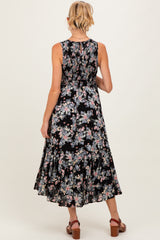 woman wearing a black floral maternity dress with a smocked back and flared skirt, showcasing a baby bump