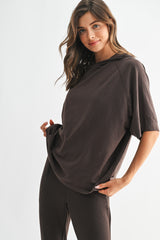 woman wearing a relaxed fit dark brown oversized t-shirt with short sleeves and a casual style