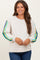woman wearing a cream maternity sweatshirt with colorful striped sleeves and a relaxed fit, smiling at the camera