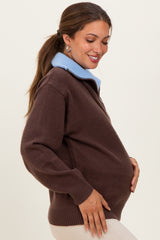 woman wearing a brown maternity sweater with a light blue collar and showing her baby bump