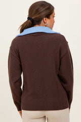 woman wearing a brown maternity sweater with a light blue collar, shown from the back